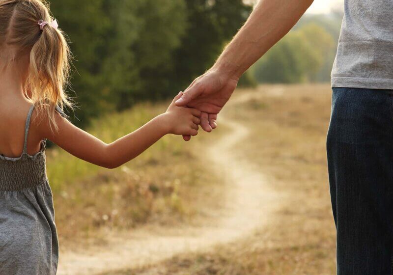 Father holding daughter's hand developing co-regulation.