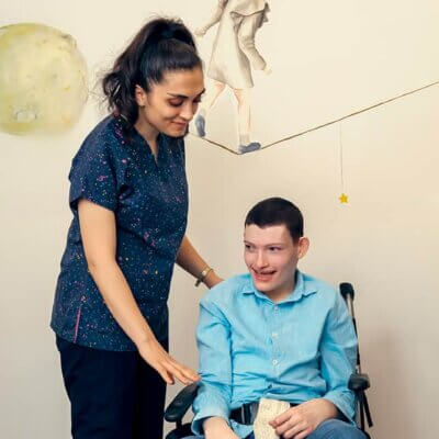 Woman with a young man with disabilities. She is advocating for his care.