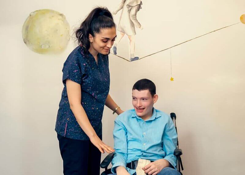 Woman with a young man with disabilities. She is advocating for his care.