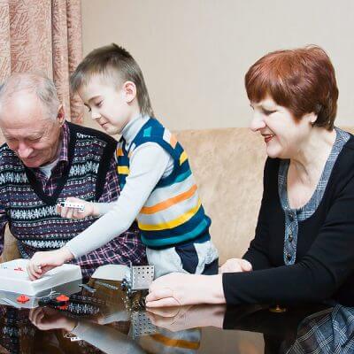 A grand mother and grand father play with their autistic grandchild