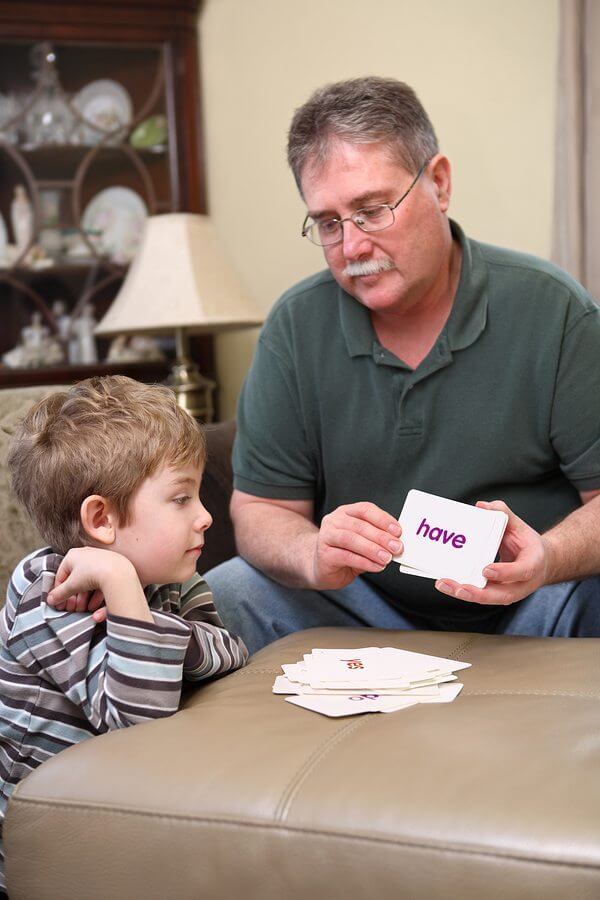 Father and son with autism studying flash cards