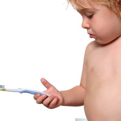 Isolated picture of toddler holding a toothbrush