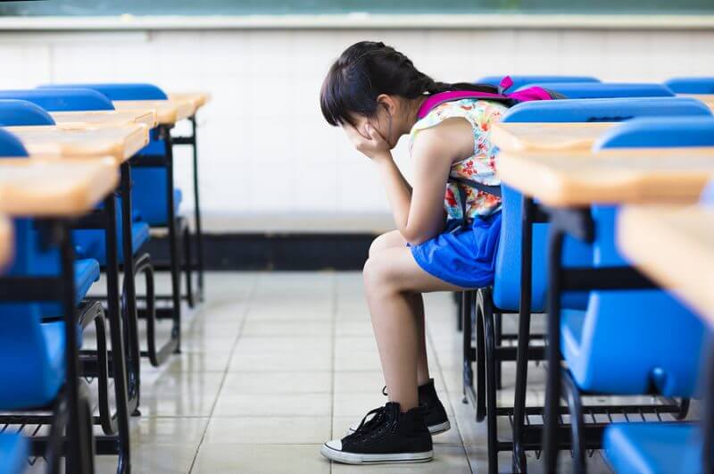 Sad Girl Sitting And Thinking In The Classroom. Girls with autism often go undiagnosed