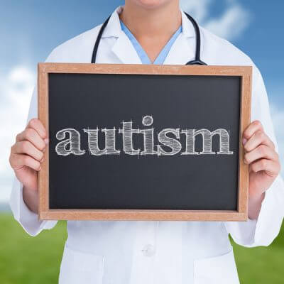 The word autism and doctor showing little blackboard against field and sky. Adult autism diagnosis