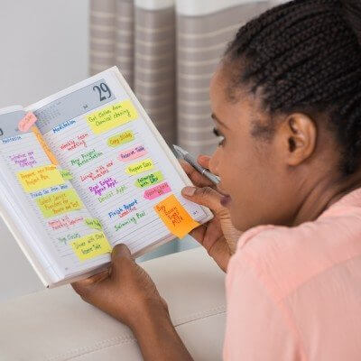Autistic black girl looking at schedule of timetable to create predictability