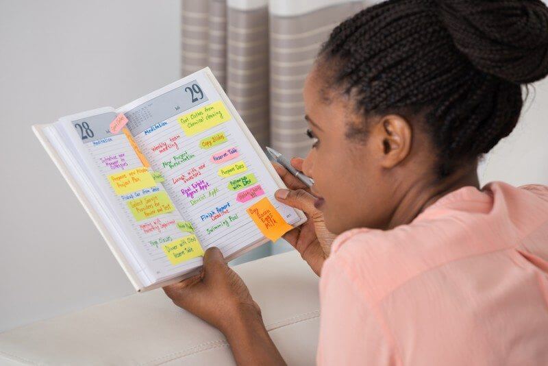 Autistic black girl looking at schedule of timetable to create predictability