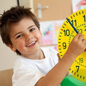 Young boy playing with a plastic clock