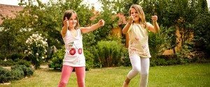 Two girls with autism in their pre teens giving a thumbs up